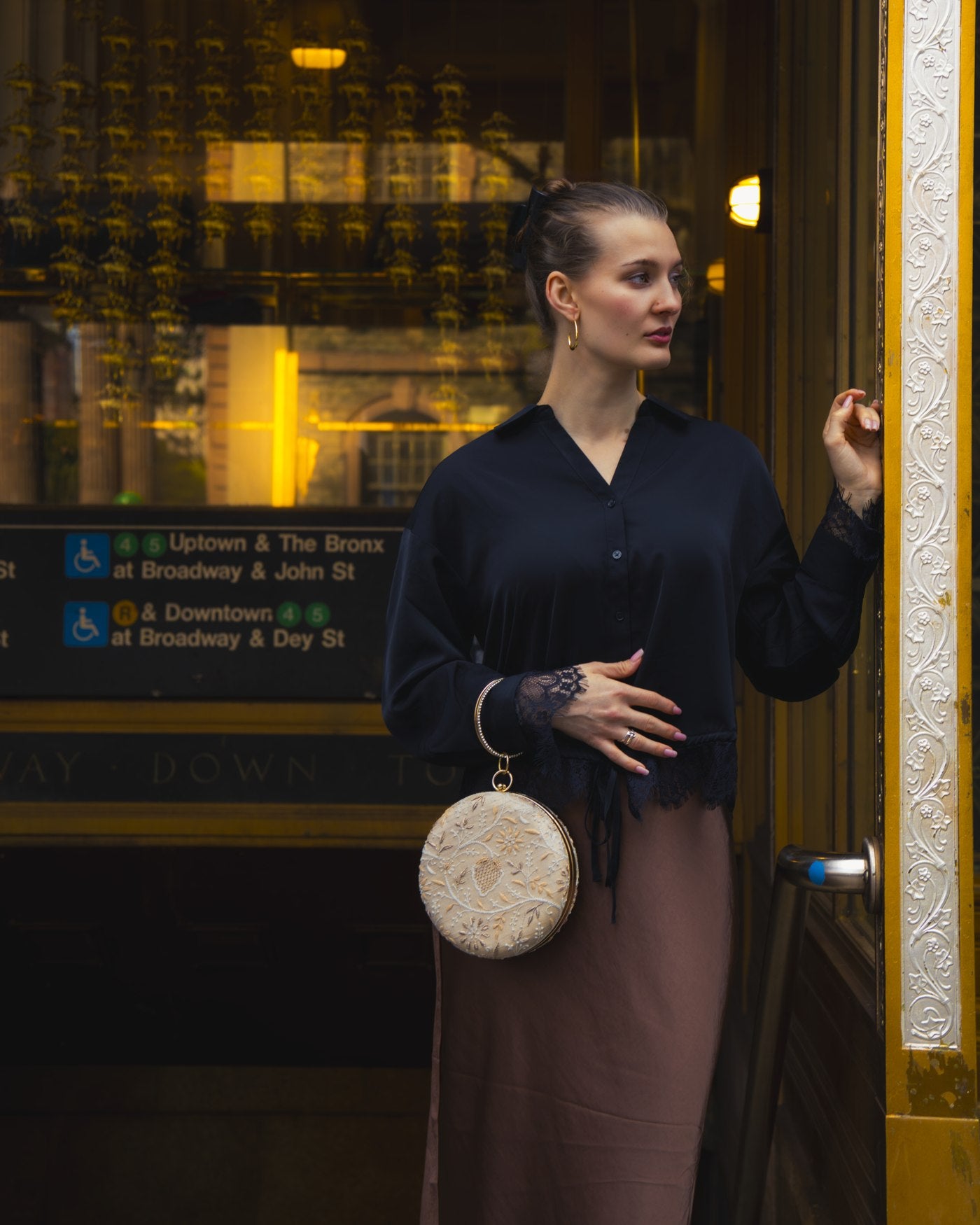 Amy carrying a cream round hand-embroidered bag in New York