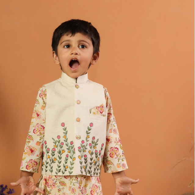 Child wearing a floral traditional outfit with a beige background